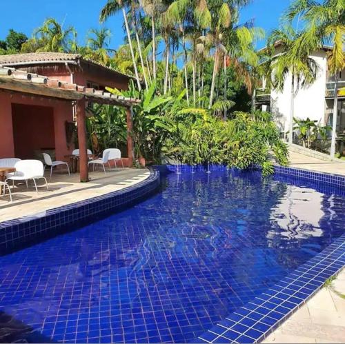 una piscina con piastrelle blu in un resort di Suite com jacuzzi privativa a Maceió