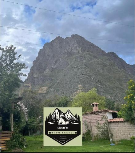 een berg op de achtergrond met een bord op de voorgrond bij Coco's vibes in Ollantaytambo