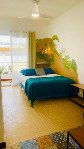a bedroom with a large bed with blue sheets at Mozaïka - Le cocon tropical in Pointe-à-Pitre