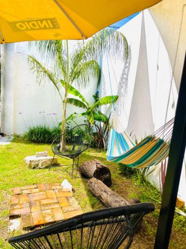 a hammock and a chair under an umbrella at Loft Industrial Petfriendly in Tlaxcala de Xicohténcatl