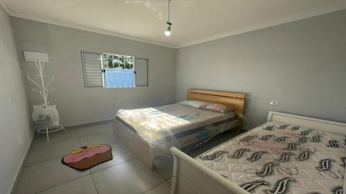 een kleine slaapkamer met een bed en een raam bij Casa Ilha comprida 2 quartos yemar in Ilha Comprida