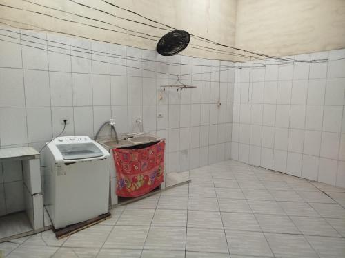 una piccola cucina con lavandino e piccolo frigorifero di Casa da Cris a Itanhaém