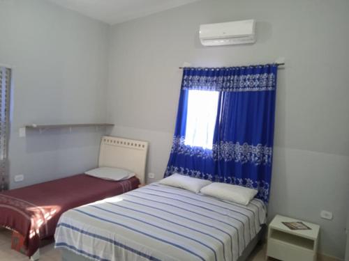 una camera da letto con un letto e una finestra di Pousada Refúgio Natural da Ilha a Ilha Comprida