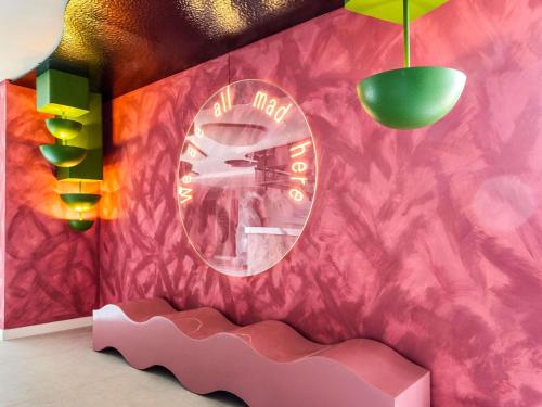 马德里Ibis Styles Madrid Airport Valdebebas的一间设有粉红色墙壁和镜子的房间