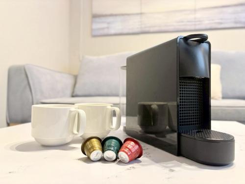 a coffee maker and two cups on a table at Koti Sopo Universal Bay 4 by Liaison in Osaka