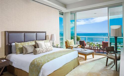 een slaapkamer met een bed en uitzicht op de oceaan bij Vidanta 2-bdrm Villa, in Nuevo Vallarta 