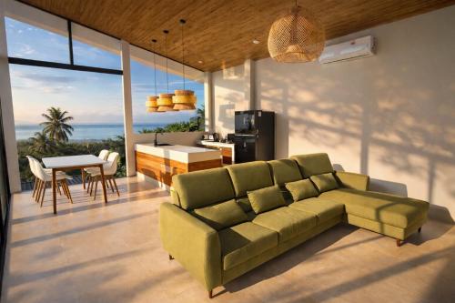 un salon avec un canapé vert et une table dans l'établissement NAHA Villa Sea View Koh Phangan, à Baan Tai