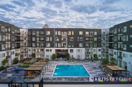 a large apartment building with a swimming pool at The 513 Flat 2! 1BR, 1Bath Apt with Pool and Riverfront View! Free Gated Parking! Only Steps from The banks & Stadiums! in Cincinnati