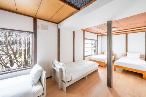 ein Schlafzimmer mit zwei Betten und zwei Fenstern in der Unterkunft KING DEER - Vacation STAY 67718v in Higashikawa