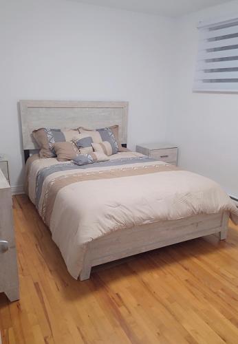 ein Schlafzimmer mit einem großen Bett mit Kissen darauf in der Unterkunft Résidence J'aime in Laval