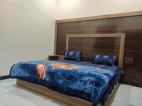 a bedroom with a large bed with a wooden headboard at Naval Kishori Kunj in Vrindāvan