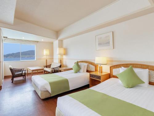 ein Hotelzimmer mit zwei Betten und einem Schreibtisch in der Unterkunft Toba Wan Wan Paradise Hotel in Toba