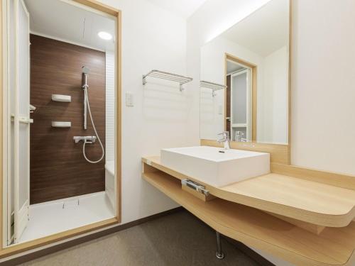 ein Badezimmer mit einem weißen Waschbecken und einem Spiegel in der Unterkunft Toba Wan Wan Paradise Hotel in Toba