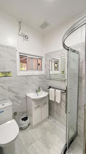 a white bathroom with a toilet and a sink at Major Innes Motel in Port Macquarie