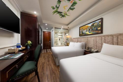 een hotelkamer met twee bedden en een bureau bij Golden Legend Palace Hotel & Travel in Hanoi