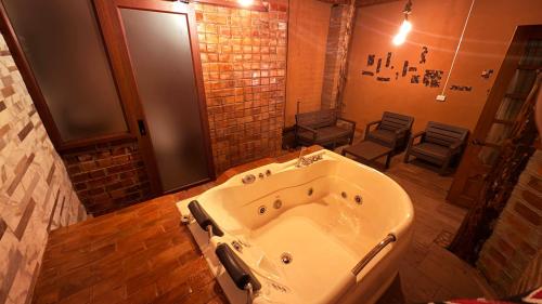 Una bañera grande en un baño con sillas. en Cabaña Real, en Ibarra