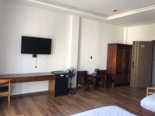 a room with a bed and a tv on the wall at Mỹ Lan hotel in Da Lat