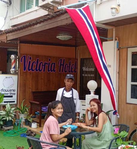 a group of people sitting at a table in front of a hotel at Victoria Hotel in Hua Hin