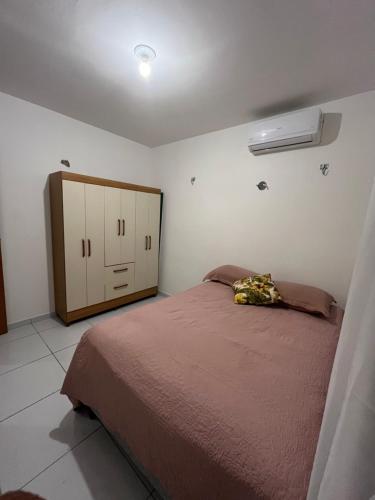 a bedroom with a bed and a cabinet in it at Village do Sol 3 - Apt compartilhado in Maioba