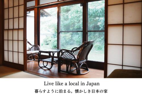 ein Raum mit Tisch und Stühlen und Fenstern in der Unterkunft Cotori 小鳥村 - Traditional Japanese House - Private Stay in Izu