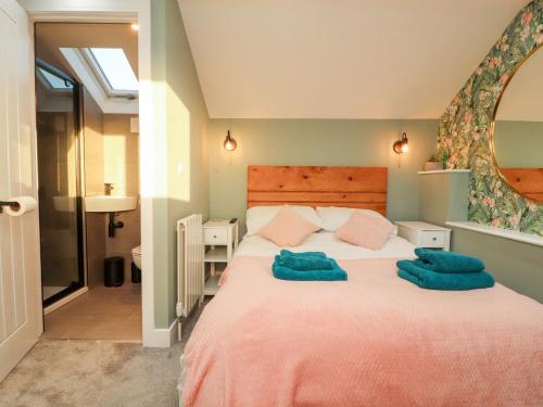 een slaapkamer met een groot bed en 2 blauwe handdoeken bij 10 Keekle Terrace in Cleator Moor