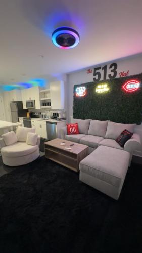 a living room with a white couch and a kitchen at The 513 Flat 2! 1BR, 1Bath Apt with Pool and Riverfront View! Free Gated Parking! Only Steps from The banks & Stadiums! in Cincinnati