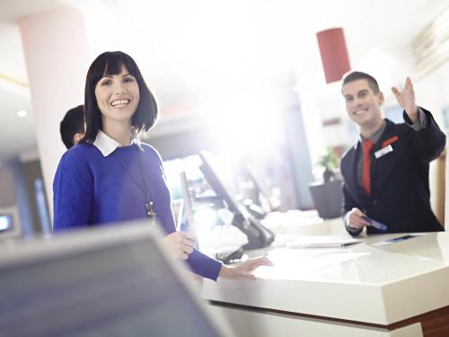 een vrouw en een man zitten aan een bureau bij Novotel Sheffield Centre in Sheffield