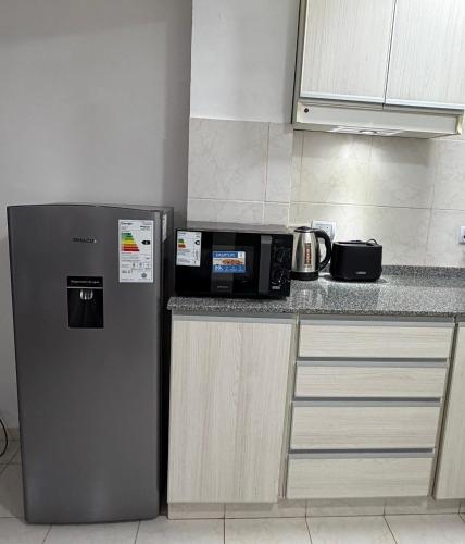 a kitchen with a microwave and a refrigerator at Departamento PA in Villa Carlos Paz