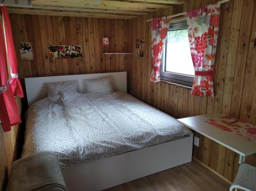 une petite chambre avec un lit et une fenêtre dans l'établissement Marina - Camp pod kaštany, à Morávka