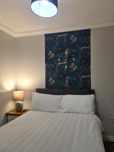 a bedroom with a bed with a painting on the wall at PR 2 BR Modern Home in Middlesbrough