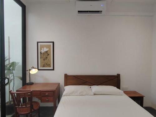 a bedroom with a bed and a table and a desk at Zen Retreat KL in Kuala Lumpur