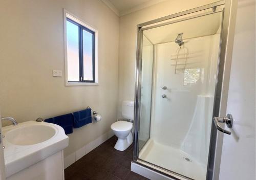 a bathroom with a shower and a sink and a toilet at The Sundowner Cabin & Tourist Park in Whyalla