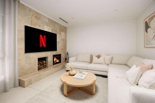 a living room with a white couch and a fireplace at Play on Balcombe in Mount Martha