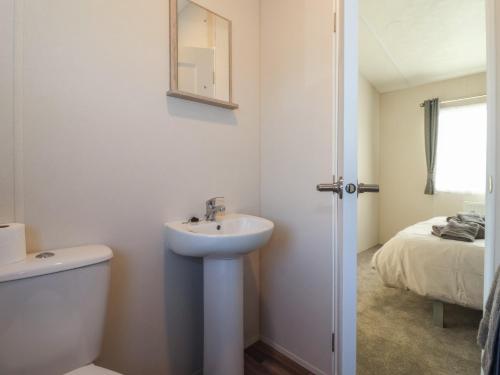 een badkamer met een wastafel, een toilet en een bed bij Meadows Park 5 in Hull