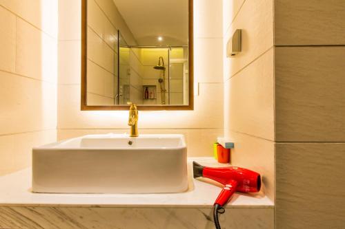 a bathroom with a white sink and a red telephone at Kaiyue Hotel Qingdao in Qingdao