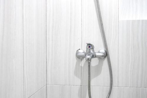 e bagno con doccia e soffione. di Sofia Residence Syariah Mitra RedDoorz a Malang