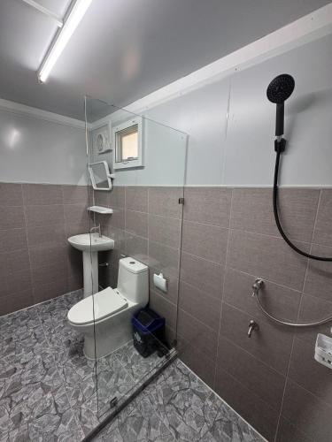 a bathroom with a shower with a toilet and a sink at Moon Jungle Bungalows in Ban Madua Wan