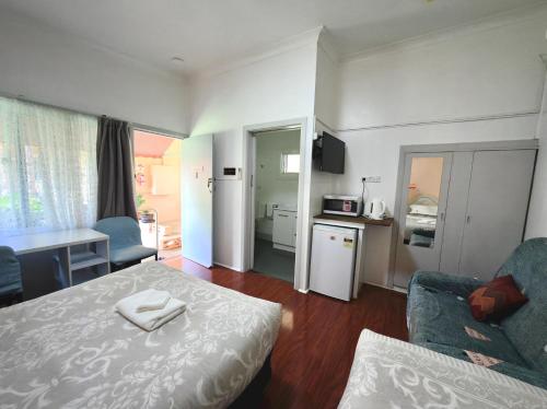 a small room with a bed and a kitchen at Major Innes Motel in Port Macquarie