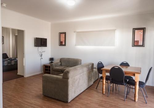 a living room with a couch and a table at The Sundowner Cabin & Tourist Park in Whyalla