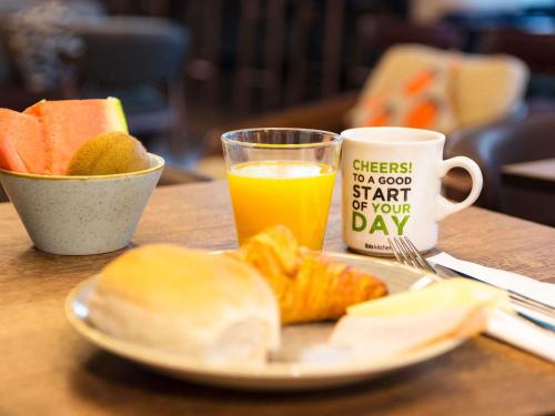 een bord eten en een kop sinaasappelsap bij ibis Amsterdam Centre in Amsterdam