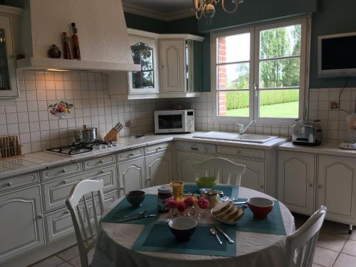 une cuisine avec une table et des chaises dans l'établissement La Maison D'Eliane, à Aire-sur-la-Lys