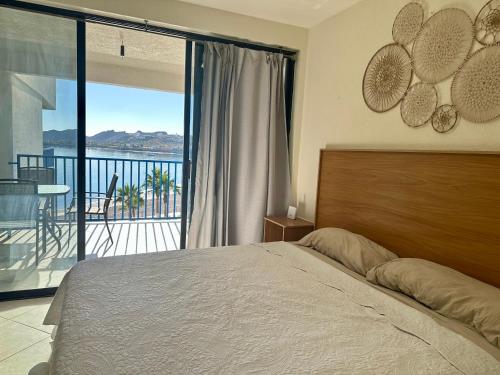 a bedroom with a bed and a balcony with a view at Hermoso condominio frente al mar in San Carlos