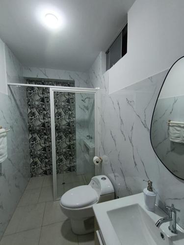 a bathroom with a toilet and a sink and a mirror at koi Residencial 301 in Chimbote