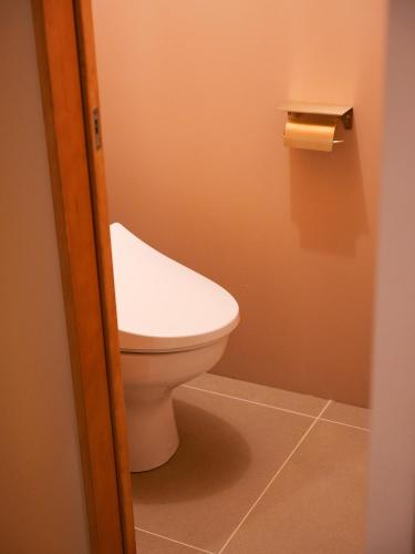 a bathroom with a toilet and a roll of toilet paper at horn ホルン in Kofu