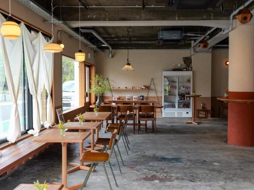 a row of tables and chairs in a room with windows at horn ホルン in Kofu
