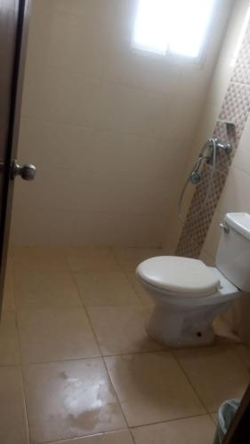 a bathroom with a toilet and a shower with a window at Alojamiento M&M in Los Paredones
