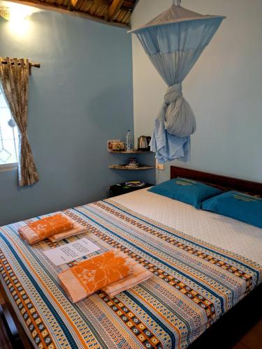 a bedroom with a bed with a quilt on it at Avalon Inn in Mandrem