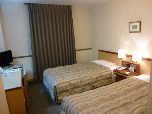 מיטה או מיטות בחדר ב-Hotel Crownhills Fukushima