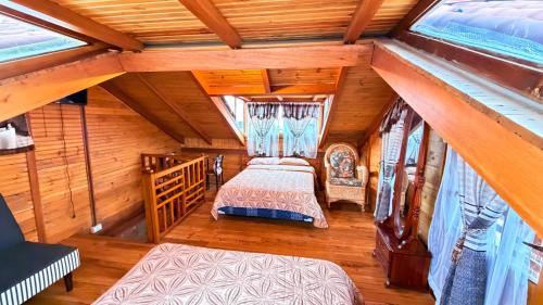 a bedroom with two beds in a attic at Cabaña Real con Yacuzzi rodeada de pavos reales in Ibarra