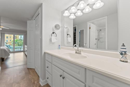 een witte badkamer met een wastafel en een spiegel bij Canaveral Sands 4202 in Cape Canaveral